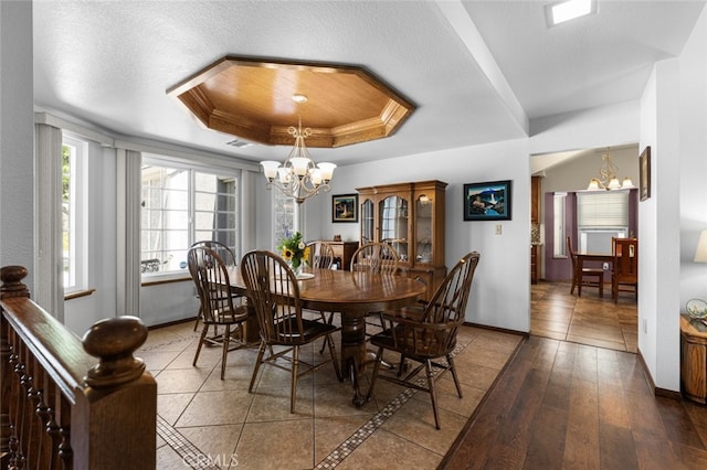 43419 37th St W, Lancaster, CA 93536 - dining space featuring a chandelier, a tray ceiling, a textured ceiling, and wood finished floors