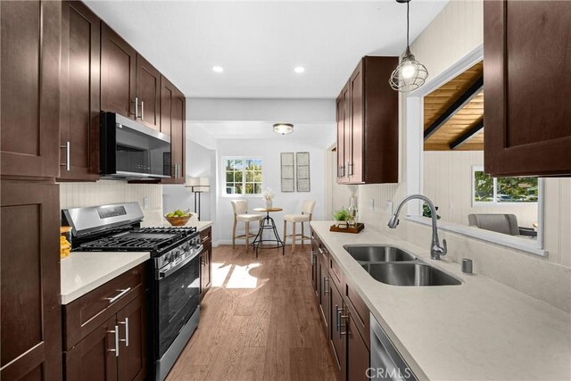 229 W Hacienda Dr, Corona, CA 92882 - kitchen with stainless steel appliances, wood finished floors, light countertops, dark brown cabinets, and recessed lighting