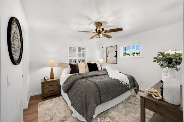 229 W Hacienda Dr, Corona, CA 92882 - bedroom with multiple windows, light wood finished floors, and ceiling fan