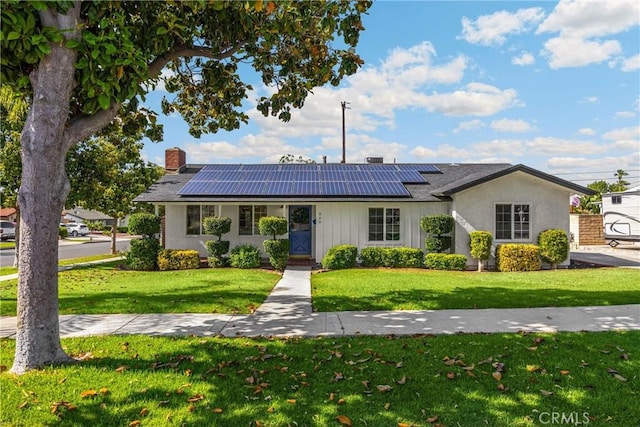 229 W Hacienda Dr, Corona, CA 92882 - view of front facade featuring a front yard, a chimney, and roof mounted solar panels