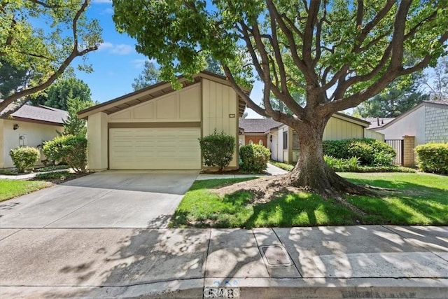548 Via Ln, Paloma, Riverside, CA 92507 - mid-century modern home featuring board and batten siding, a garage, and concrete driveway