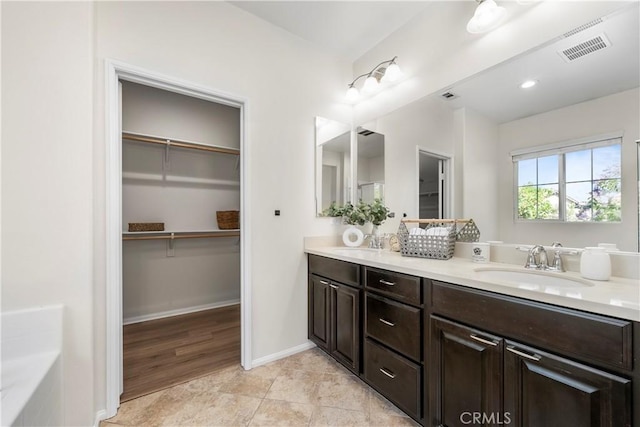 8022 Cresta Bella Rd, Rancho Cucamonga, CA 91730 - full bathroom featuring double vanity, a walk in closet, tile patterned floors, and a tub to relax in