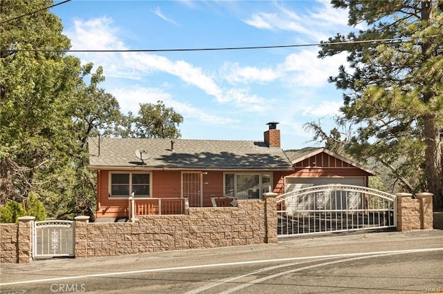 30400 Live Oak Dr, Running Springs, CA 92382 - view of front of property featuring a gate, a chimney, a fenced front yard, driveway, and a garage