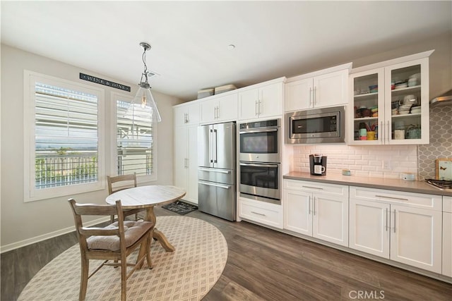 4048 Tradewinds Dr, Oxnard, CA 93035 - kitchen with appliances with stainless steel finishes, backsplash, glass insert cabinets, and white cabinetry