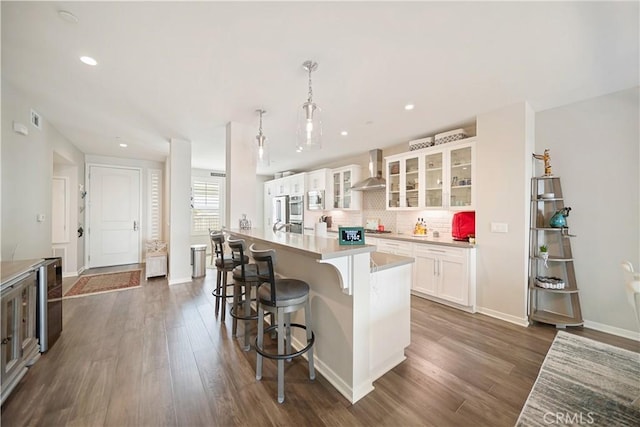 4048 Tradewinds Dr, Oxnard, CA 93035 - kitchen with wall chimney exhaust hood, dark wood finished floors, appliances with stainless steel finishes, white cabinets, and recessed lighting
