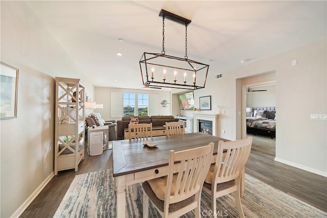 4048 Tradewinds Dr, Oxnard, CA 93035 - dining area featuring dark wood-style floors, a chandelier, and a glass covered fireplace