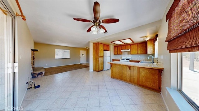 19171 Carlisle Rd, Apple Valley, CA 92307 - kitchen featuring white appliances, open floor plan, brown cabinets, a peninsula, and a ceiling fan