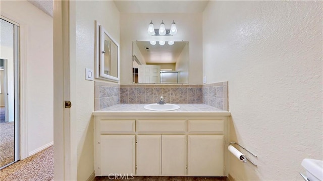 19171 Carlisle Rd, Apple Valley, CA 92307 - bathroom with decorative backsplash, a textured wall, and vanity
