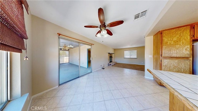 19171 Carlisle Rd, Apple Valley, CA 92307 - spare room with ceiling fan, light tile patterned floors, and a fireplace with raised hearth