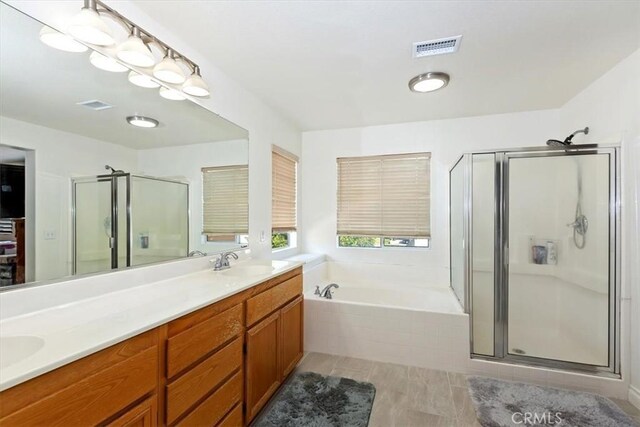 7509 Woodstream Ct, Rancho Cucamonga, CA 91739 - full bath featuring a stall shower, double vanity, a bath, and tile patterned flooring