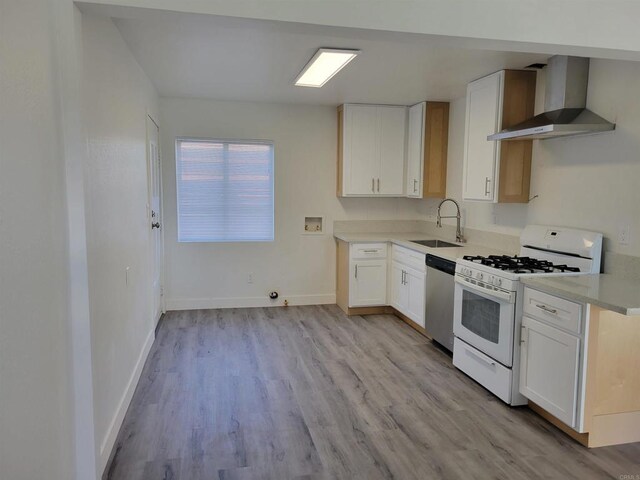 3222 42nd St, San Diego, CA 92105 - kitchen with wall chimney exhaust hood, white gas range oven, dishwasher, light wood-style flooring, and white cabinetry