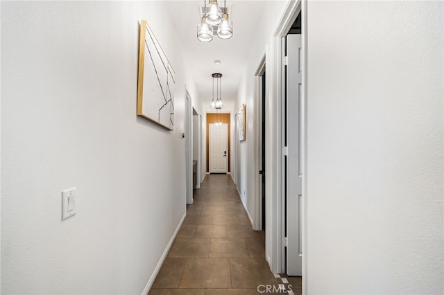 43875 Spiaggia Pl, Indio, CA 92203 - hallway featuring dark tile patterned flooring and a chandelier