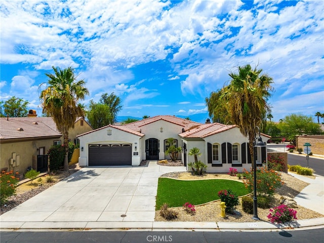43875 Spiaggia Pl, Indio, CA 92203 - mediterranean / spanish-style home with an attached garage, driveway, stucco siding, and a tile roof