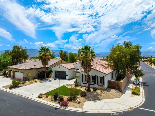 43875 Spiaggia Pl, Indio, CA 92203 - mediterranean / spanish home featuring a mountain view, driveway, stucco siding, a garage, and a tiled roof