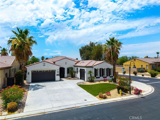 43875 Spiaggia Pl, Indio, CA 92203 - mediterranean / spanish house featuring an attached garage, stucco siding, driveway, a tile roof, and a front yard