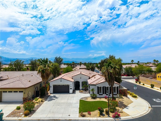 43875 Spiaggia Pl, Indio, CA 92203 - mediterranean / spanish house featuring concrete driveway, an attached garage, and a mountain view