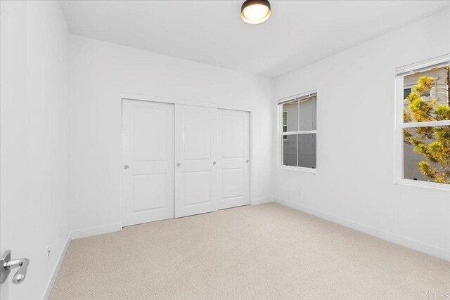 7147 Sitio Bahia, Carlsbad, CA 92009 - unfurnished bedroom featuring light colored carpet and a closet