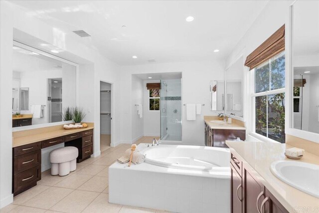 7147 Sitio Bahia, Carlsbad, CA 92009 - bathroom featuring a stall shower, two vanities, a bath, healthy amount of natural light, and recessed lighting