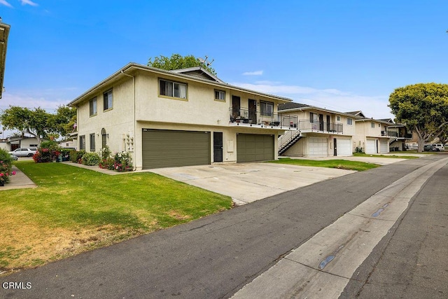 656 W Hemlock St, Port Hueneme, CA 93041 - townhome / multi-family property with a garage, stucco siding, a front yard, driveway, and a residential view