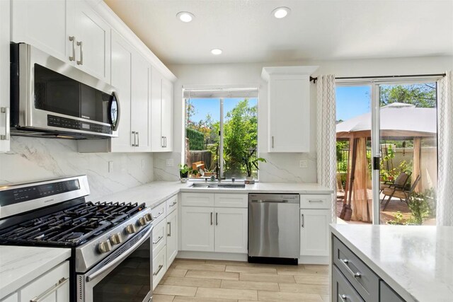 2344 Greenbriar Dr Unit A, Chula Vista, CA 91915 - kitchen featuring stainless steel appliances, plenty of natural light, recessed lighting, decorative backsplash, and light stone countertops