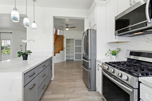 2344 Greenbriar Dr Unit A, Chula Vista, CA 91915 - kitchen with appliances with stainless steel finishes, light wood-type flooring, light stone countertops, white cabinets, and a ceiling fan
