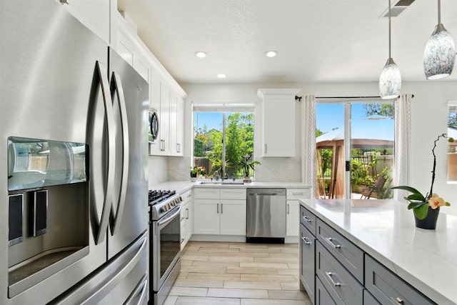 2344 Greenbriar Dr Unit A, Chula Vista, CA 91915 - kitchen with appliances with stainless steel finishes, gray cabinetry, tasteful backsplash, white cabinetry, and pendant lighting
