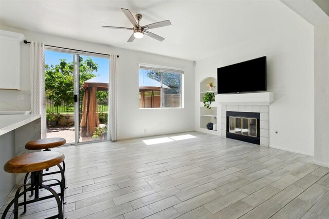 2344 Greenbriar Dr Unit A, Chula Vista, CA 91915 - unfurnished living room featuring a ceiling fan, light wood-style flooring, a tiled fireplace, and built in features