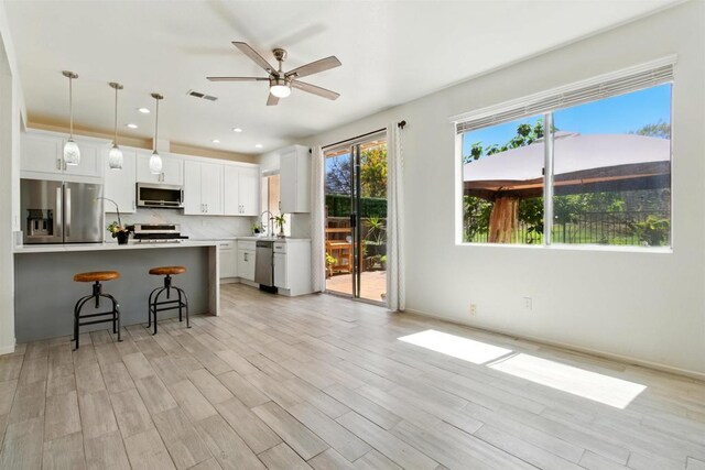 2344 Greenbriar Dr Unit A, Chula Vista, CA 91915 - kitchen featuring appliances with stainless steel finishes, a kitchen bar, light countertops, light wood-style floors, and recessed lighting