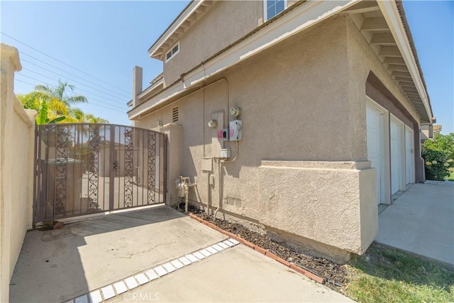 30528 Covecrest Cir, Menifee, CA 92584 - view of side of property with stucco siding, a gate, and a garage