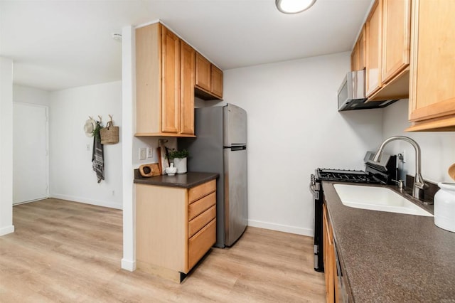 13754 Mango Dr Unit 111, Del Mar, CA 92014 - kitchen featuring dark countertops, appliances with stainless steel finishes, and light wood finished floors