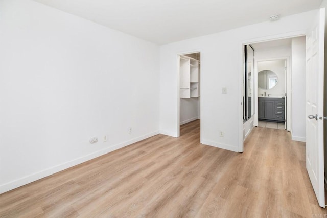 13754 Mango Dr Unit 111, Del Mar, CA 92014 - unfurnished bedroom featuring light wood-style flooring, a spacious closet, and a closet