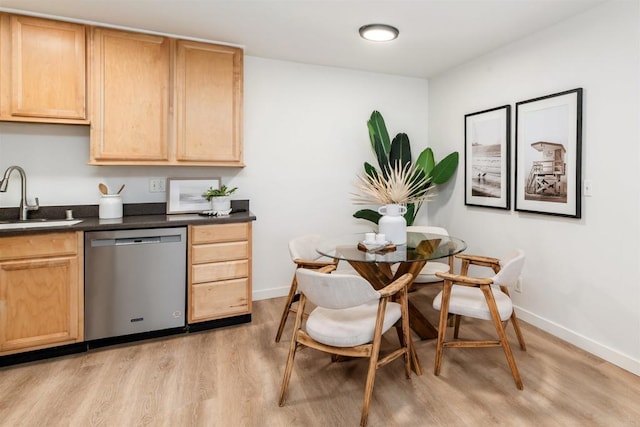 13754 Mango Dr Unit 111, Del Mar, CA 92014 - kitchen with stainless steel dishwasher, light brown cabinetry, dark countertops, and light wood-type flooring