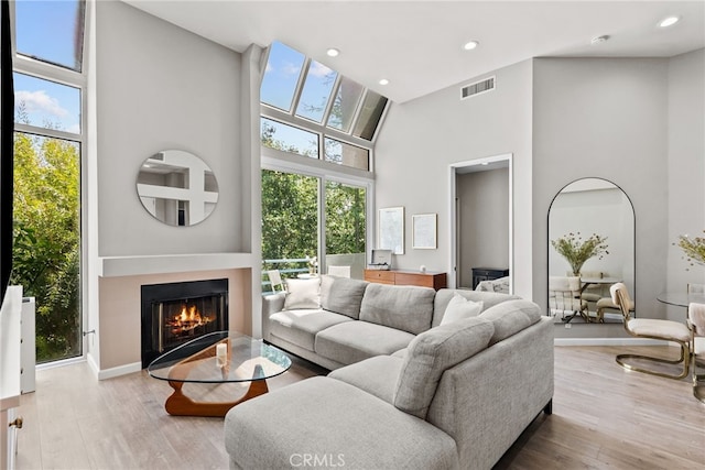 5151 Balboa Blvd Unit 303, Encino, CA 91316 - living area featuring a high ceiling, a lit fireplace, plenty of natural light, wood finished floors, and recessed lighting