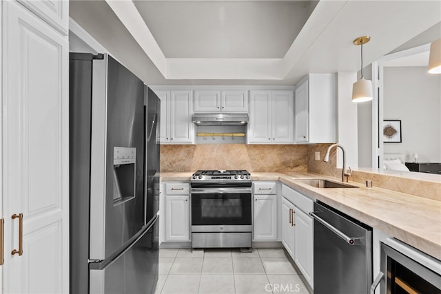 5151 Balboa Blvd Unit 303, Encino, CA 91316 - kitchen featuring stainless steel appliances, light countertops, light tile patterned floors, white cabinetry, and a tray ceiling