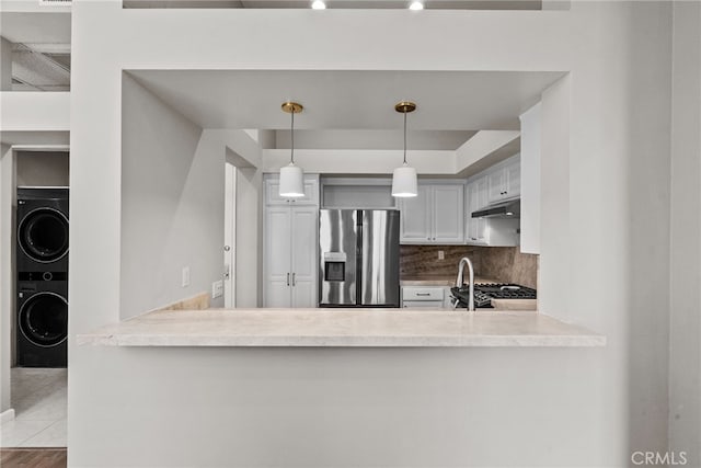 5151 Balboa Blvd Unit 303, Encino, CA 91316 - kitchen featuring stainless steel fridge with ice dispenser, stacked washer and clothes dryer, a peninsula, and under cabinet range hood