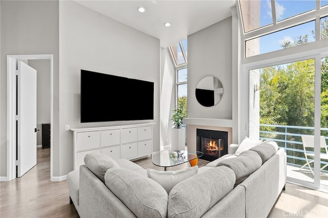 5151 Balboa Blvd Unit 303, Encino, CA 91316 - living area featuring plenty of natural light, wood finished floors, a glass covered fireplace, a high ceiling, and recessed lighting