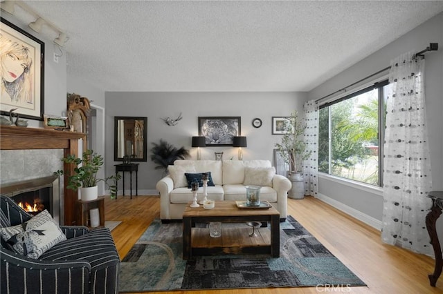 708 S Vecino Dr, Glendora, CA 91740 - living room with a textured ceiling, wood finished floors, and a tiled fireplace