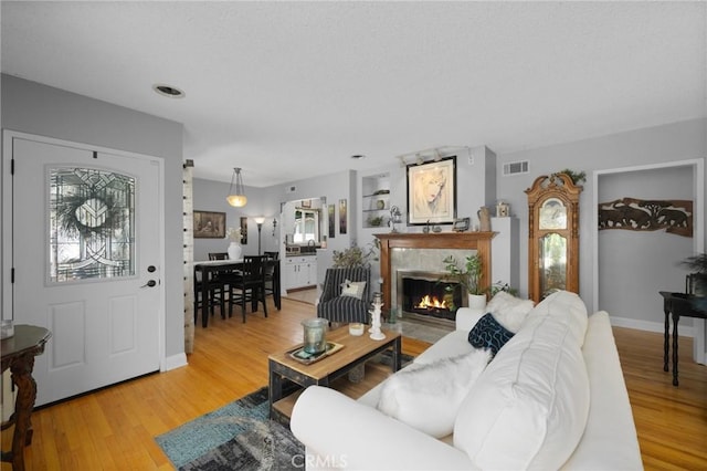 708 S Vecino Dr, Glendora, CA 91740 - living room with light wood-style flooring and a warm lit fireplace