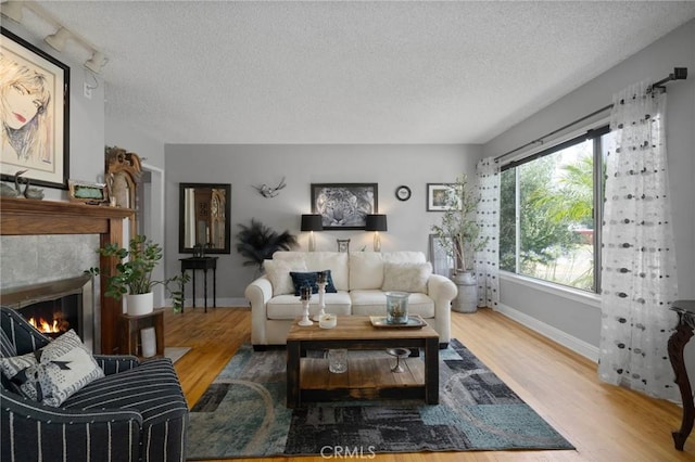708 S Vecino Dr, Glendora, CA 91740 - living area featuring a textured ceiling, wood finished floors, and a tile fireplace