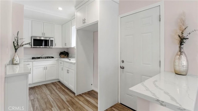 4348 Lima St, Los Angeles, CA 90011 - kitchen with stainless steel microwave, gas stovetop, white cabinets, and recessed lighting