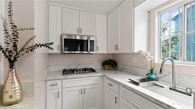 4348 Lima St, Los Angeles, CA 90011 - kitchen featuring stainless steel appliances, plenty of natural light, white cabinets, and light stone counters