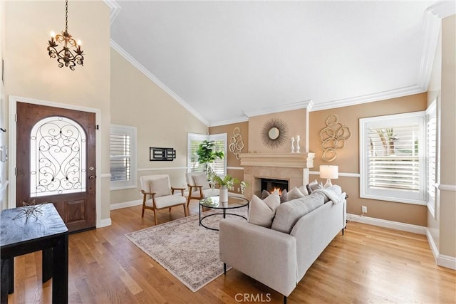 25 Westbrook Ln, Pomona, CA 91766 - living room featuring a lit fireplace, light wood-style floors, a chandelier, high vaulted ceiling, and ornamental molding