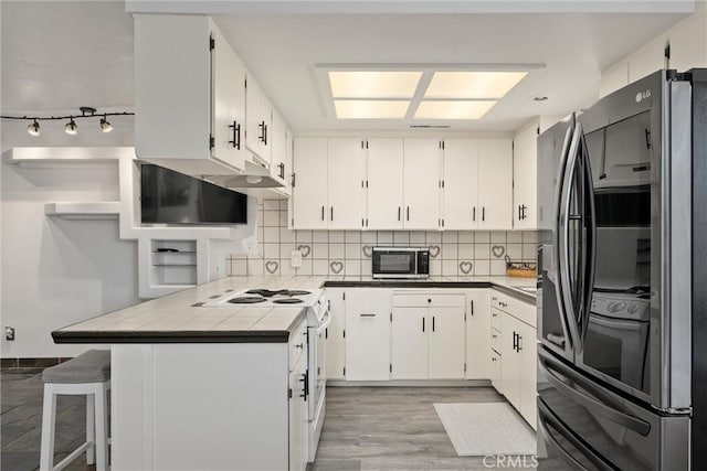 2427 Ceanothus Ave, Chico, CA 95926 - kitchen with stainless steel appliances, tile countertops, decorative backsplash, and white cabinets