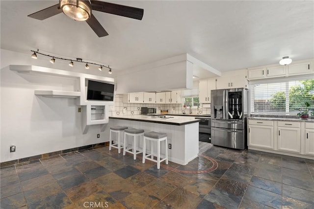 2427 Ceanothus Ave, Chico, CA 95926 - kitchen with stainless steel fridge with ice dispenser, stone tile flooring, white cabinetry, a peninsula, and decorative backsplash