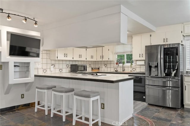 2427 Ceanothus Ave, Chico, CA 95926 - kitchen featuring stainless steel fridge, tasteful backsplash, white cabinets, a peninsula, and dark stone finish floors