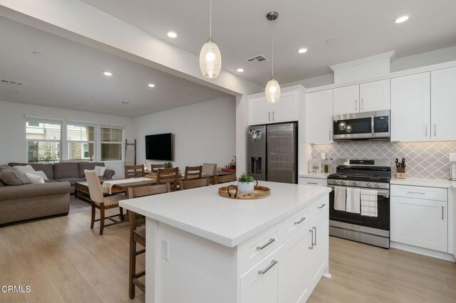 751 Winchester Dr, Oxnard, CA 93036 - kitchen featuring stainless steel appliances, open floor plan, decorative backsplash, a center island, and light wood-type flooring