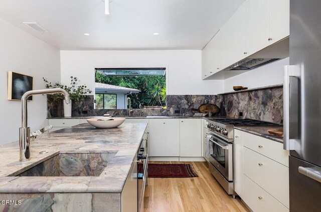 808 Inverness Dr, La Canada Flintridge, CA 91011 - kitchen with stainless steel appliances, light wood-type flooring, white cabinets, dark stone counters, and backsplash