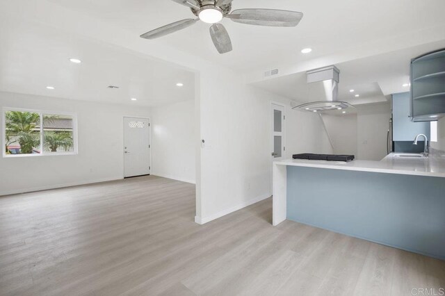 814 Hollister St Unit B, Otay Mesa, CA 92154 - kitchen with open shelves, light wood-style flooring, ceiling fan, light countertops, and island range hood