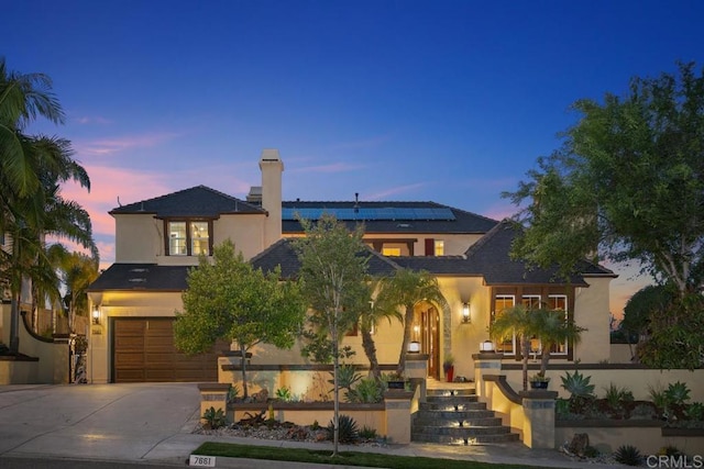7661 Sitio Algodon, Carlsbad, CA 92009 - traditional-style home featuring stucco siding, driveway, an attached garage, solar panels, and a chimney