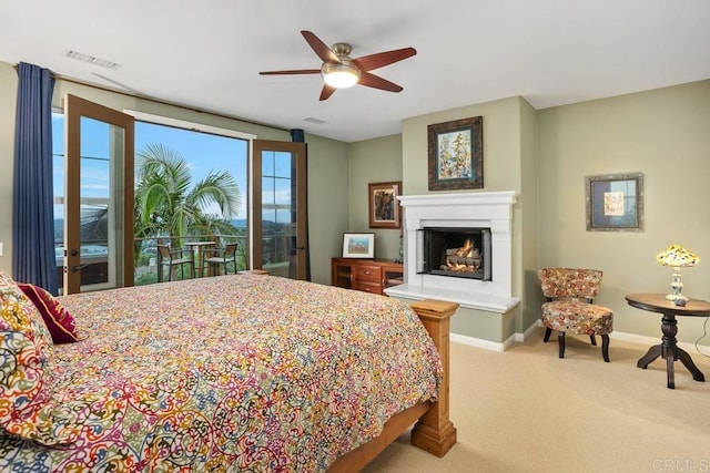 7661 Sitio Algodon, Carlsbad, CA 92009 - bedroom with carpet, a warm lit fireplace, access to exterior, and a ceiling fan